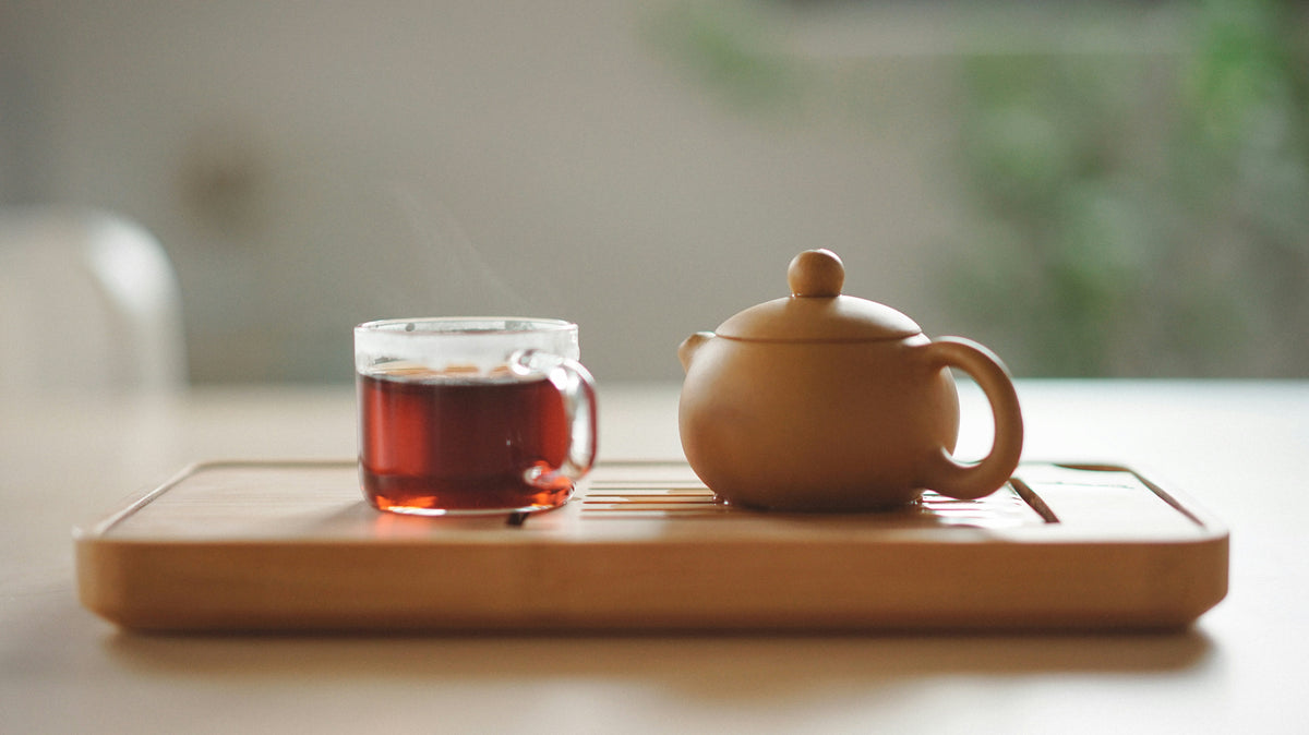 Café et feuilles de cascara sur une surface brune, créant une ambiance chaleureuse et naturelle.