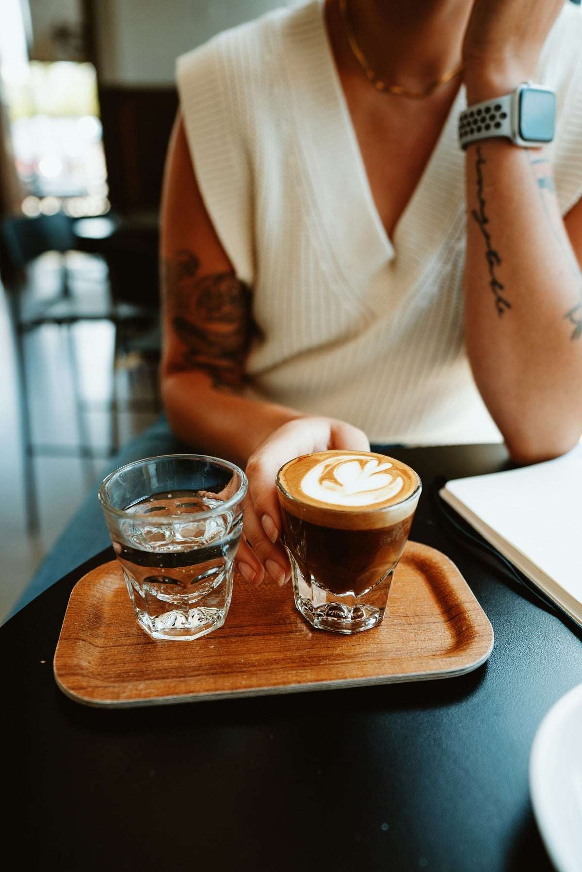 Préparation d'un cortado dans un café de spécialité avec verre d'eau
