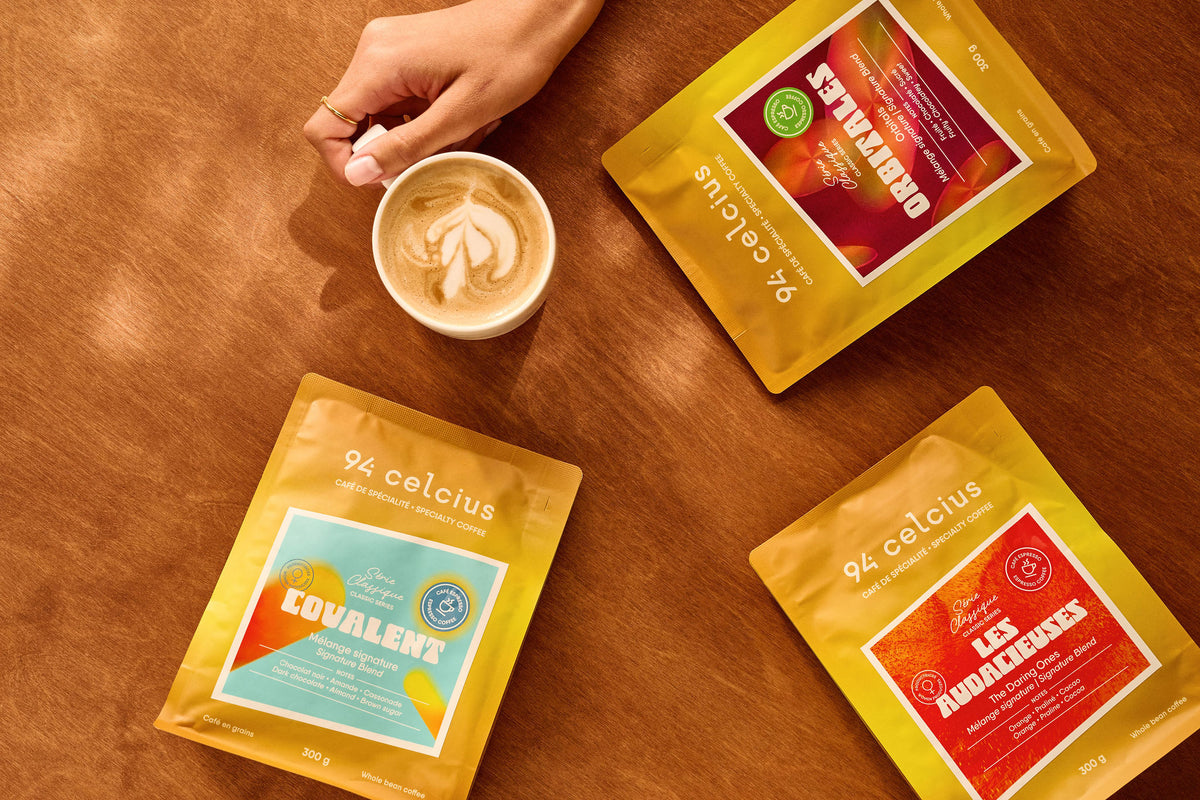 Latté de café de spécialité entouré de 3 sacs jaunes 94 celcius